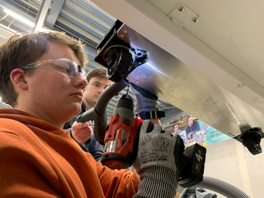 Drilling a hole into the drivetrain plate to mount the swerve modules